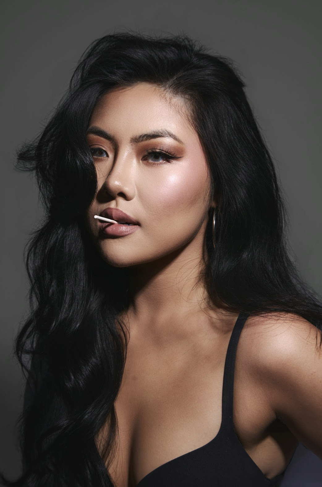 Vivian True with a lollipop, studio portrait with soft lighting