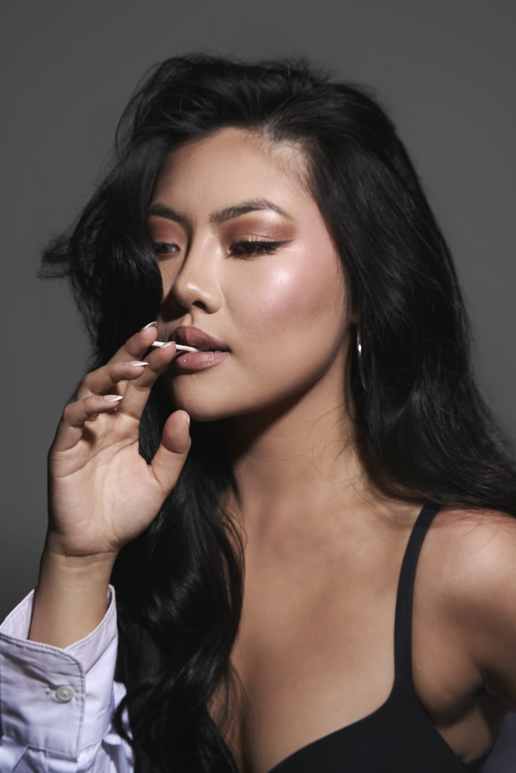Vivian True with a lollipop at her lips, studio close-up portrait